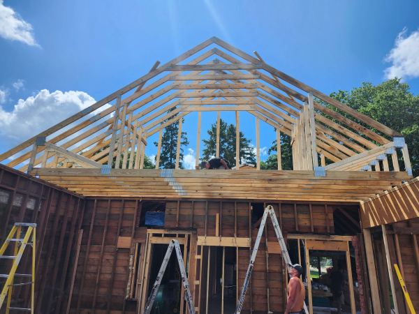 Second-story home addition with new roof trusses being framed